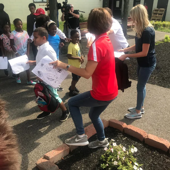 Candid photo of volunteers and kids at the Back to School Program